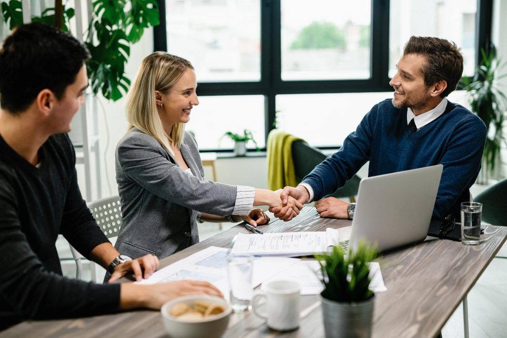 A smiling couple shaking hands for fix and flip loan